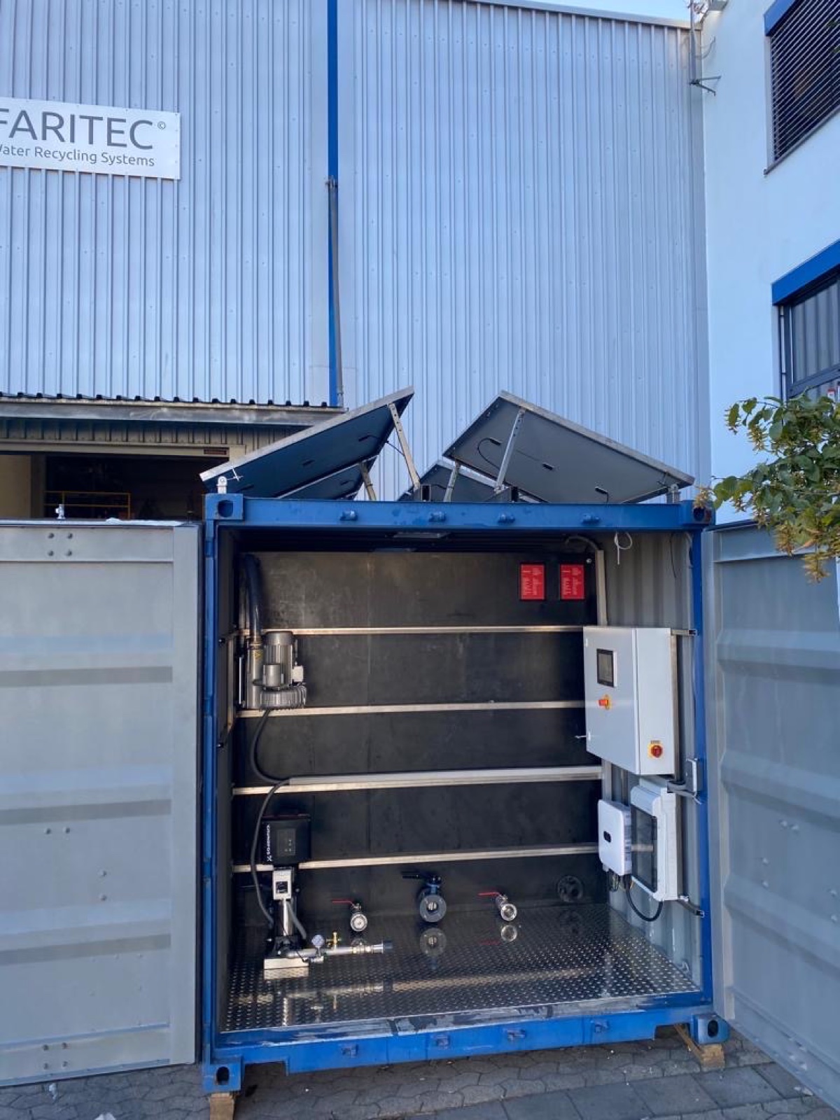 Geopende FARITEC-container met ingebouwde techniek en zonnepanelen op het dak