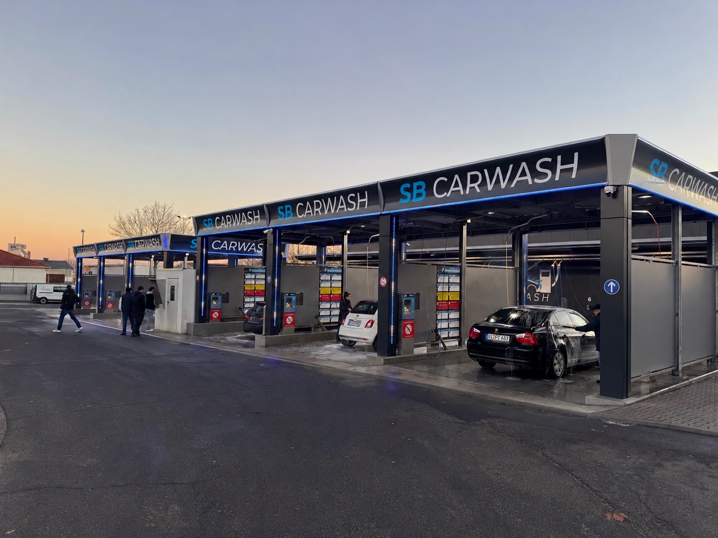Zelfbedieningscarwash met meerdere wasboxen en verlichte bedieningspanelen